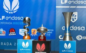 Los trofeos de la Copa de la Reina, la Supercopa y la Liga Femenina Endesa sobre tres pedestales ante un fondo azul
