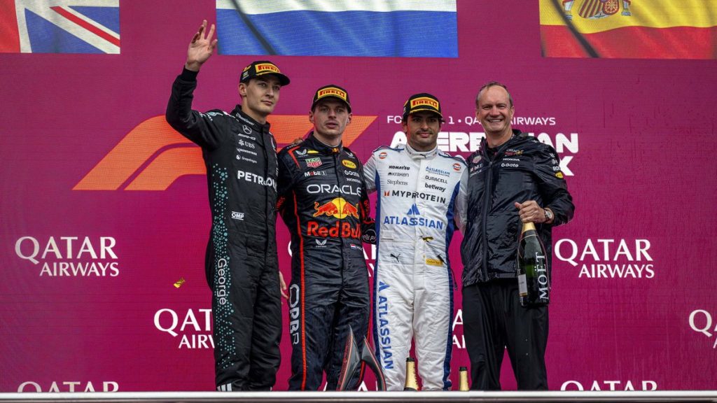 George Russell, Max Verstappen y Carlos Sainz posan en el podio de Bakú delante de las banderas británica, neerlandesa y española