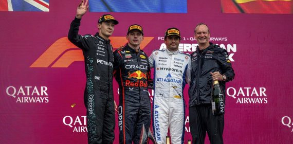 George Russell, Max Verstappen y Carlos Sainz posan en el podio de Bakú delante de las banderas británica, neerlandesa y española