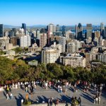 Visitantes en el mirador del Mont Royal con los rascacielos del centro de Montreal y el río San Lorenzo al fondo