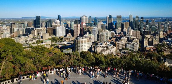 Visitantes en el mirador del Mont Royal con los rascacielos del centro de Montreal y el río San Lorenzo al fondo