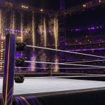 Ring de lucha libre vacío en el centro de un gran estadio al aire libre de noche, con luces moradas y chispas al fondo