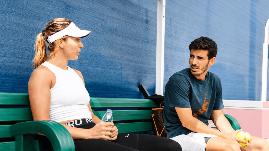Pol Lorente sentado junto a Paula Badosa durante una sesión de entrenamiento.