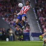 Jonathan David gana un balón aéreo ante la mirada de Diogo Dalot en el partido entre el Atlético de Madrid y el Manchester United de la fase liga de la Champions 2026/27.