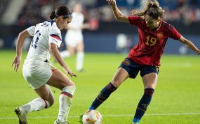Olga Carmona, de rojo, protege el balón ante Sophia Smith, de blanco, sobre el césped