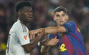 Aurélien Tchouaméni y Gerard Martín se agarran en una acción previa a un saque de esquina durante el Clásico entre el FC Barcelona y Real Madrid disputado en el Camp Nou y correspondiente a LaLiga 2026/27.