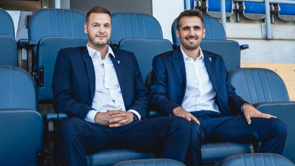 Andrés Jornet (derecha) y Damián Pedrosa (izquierda) posan sentados en el palco del estadio del ZTE húngaro.