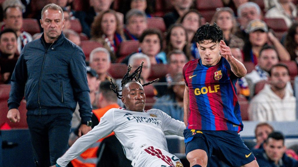 Hansi Flick observa desde la zona técnica una disputa entre Xavi Espart y Yan Diomande durante el FC Barcelona - Real Madrid de LaLiga 2026/27.
