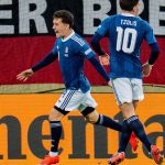 Konstantinos Karetsas celebra, junto a Christos Tzolis, el gol anotado por Dimitris Kourbelis en la victoria de Grecia frente a Alemania en Augsburgo, en un partido correspondiente a la Nations League 2026/27.