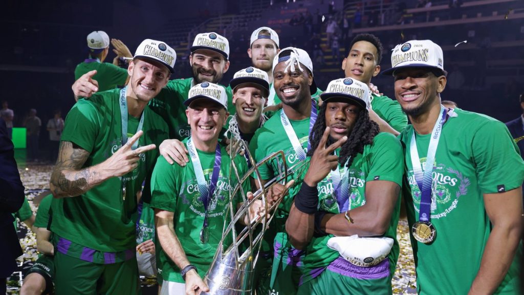 Los jugadores del Unicaja, con gorras de campeones y medallas, celebran junto al trofeo