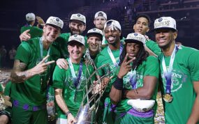 Los jugadores del Unicaja, con gorras de campeones y medallas, celebran junto al trofeo